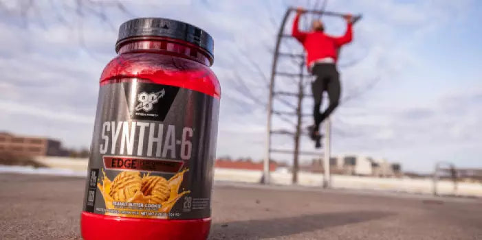 Syntha-6 Edge protein powder container with a person exercising in the background.