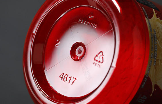 Bottom view of a red plastic container, possibly for protein powder, showing recycling symbols and the number 4617.