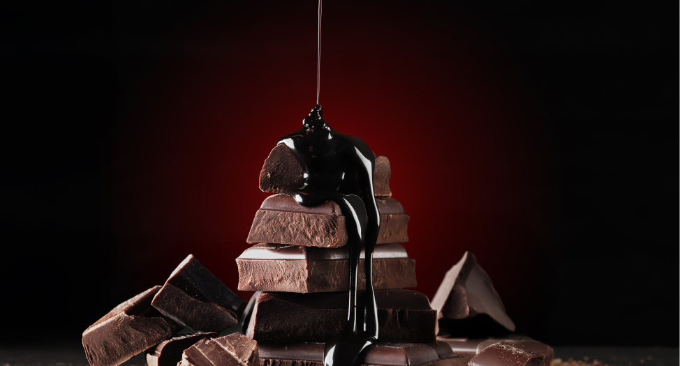 Stack of chocolate pieces with dark chocolate syrup pouring over them.