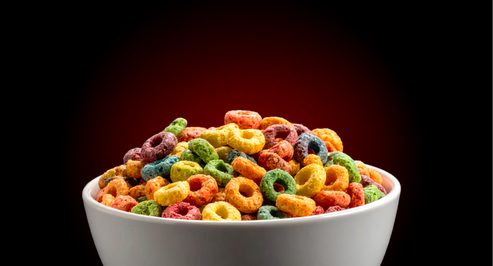 Bowl of colorful cereal loops against a dark background.